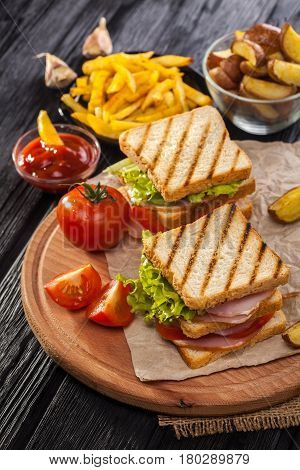 Club Sandwich With Tomato, Lettuce, Bacon, Ham And French Fries
