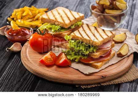 Club Sandwich With Tomato, Lettuce, Bacon, Ham And French Fries