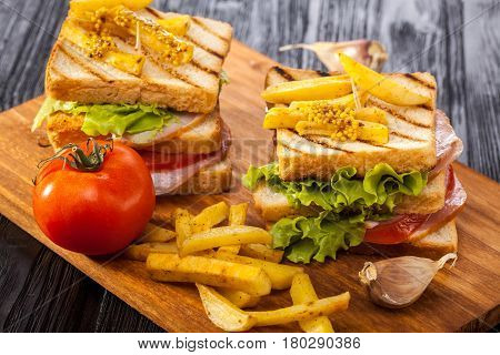 Club Sandwich With Tomato, Lettuce, Bacon, Ham And French Fries