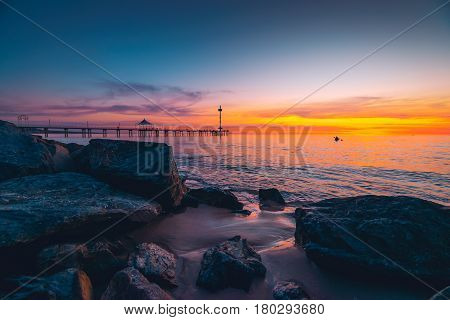 People walking along Brighton Jetty at sunset. South Australia