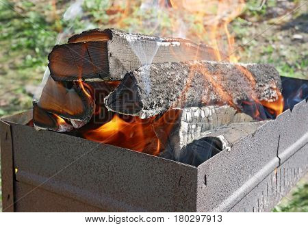 Firewood Burns In Rusty Metal Tray