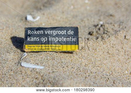 Kijkduin the Netherlands - April 6 2017: health warning on cigarette packet left on beach