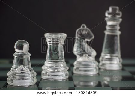 Glass chess team: king pawn knight and rook on black