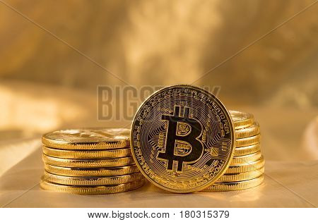 Stack of bit coins or bitcoin on gold background to illustrate blockchain and cyber currency