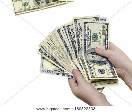 A lot of hundred dollar bills in the hands of a child on a white isolated background
