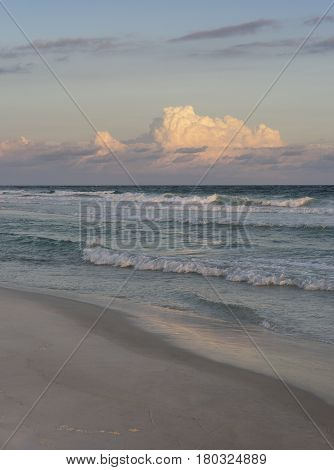 Sunset at a beautiful Florida beach with crisp surf and puffy pink clouds.
