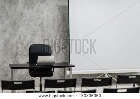 Modern university group study room with white desk and chairs.