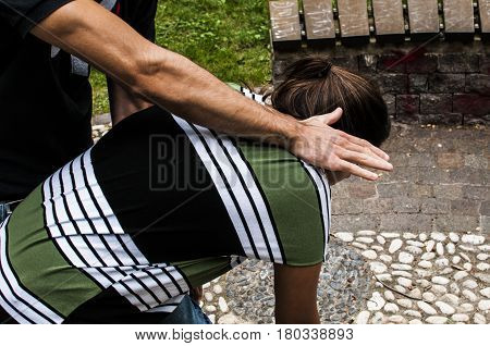 a guy helping a young girl with the heimlich desobstruction while she's choking