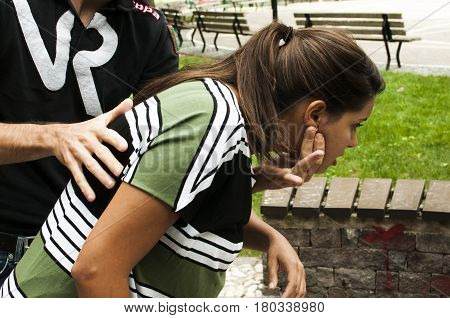 a guy helping a young girl with the heimlich desobstruction while she's choking