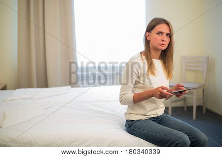Young smiling woman sitting in the bed at home and connecting with a tablet, relax and leisure concept.