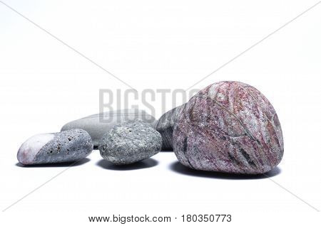 Some sea pebbles on white background. Side view. Close-up