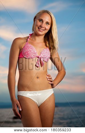 Young Stilish Woman In Pink Short Summer Dress Walks Around A Costal City On Her Vacations