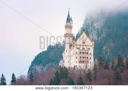 World-famous tourist attraction in the Bavarian Alps, fairytale Neuschwanstein or New Swanstone Castle, the 19th century Romanesque Revival palace in the foggy day, Hohenschwangau, Bavaria, Germany