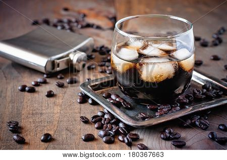 Kahlua liqueur in glasses with coffee beans on a wooden background alcoholic Mexican drink selective focus toned image