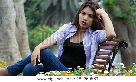 Unhappy Serious Girl Sitting on a Park Bench