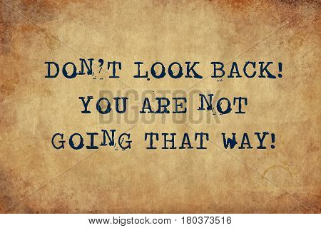 Inspiring motivation quote with typewriter text don't look back you are not going that way. Distressed Old Paper with Typing image.