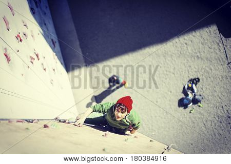 Rock climber reaching for his next hand hold Joshua Tree National Park.