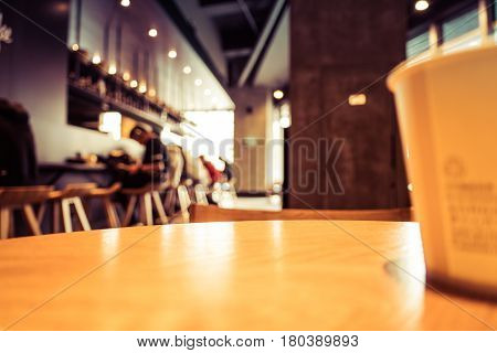 A cup of coffee - cafe blur background with warm tones