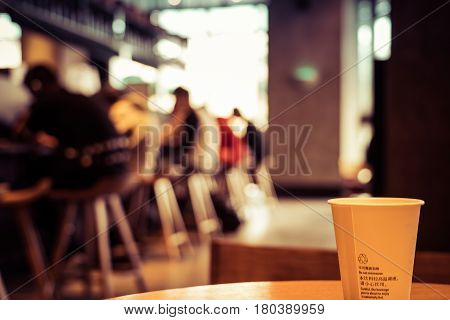 A cup of coffee - cafe blur background with warm tones