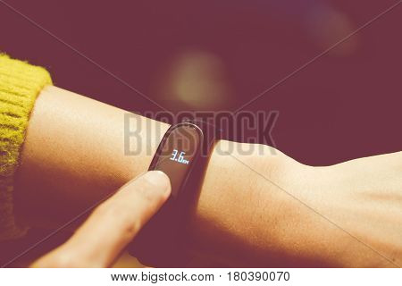 Women touching fitness smart band on her hand