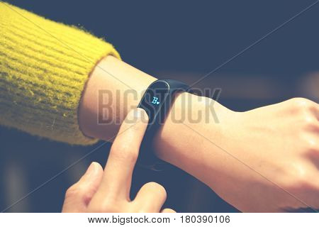 Women touching fitness smart band on her hand