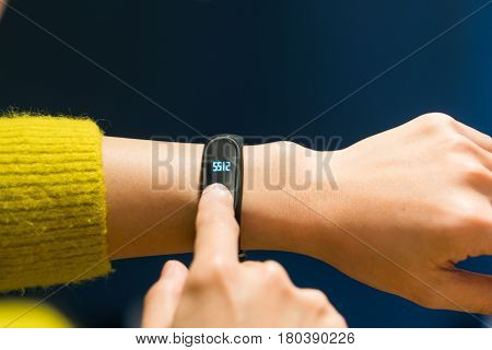 Women touching fitness smart band on her hand
