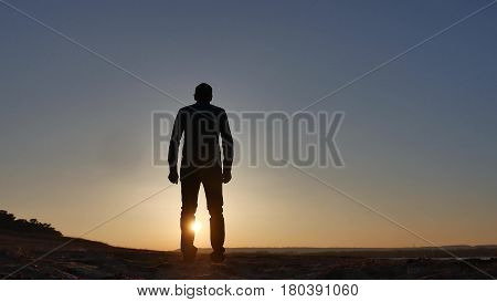 freedom. Man stands on cliff sunset silhouette hand in lifestyle the sides
