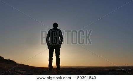 freedom. Man stands on cliff sunset silhouette hand in lifestyle the sides
