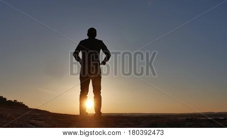 freedom. Man stands on cliff sunset silhouette hand lifestyle in the sides