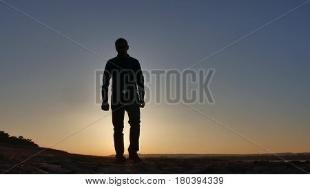 freedom. Man stands on cliff sunset silhouette hand lifestyle in the sides
