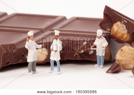 Miniature people: A chef and cooks in front of a chocolate bar