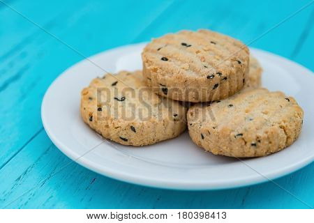 side view biscuit with seasame on dish on a blue wood background