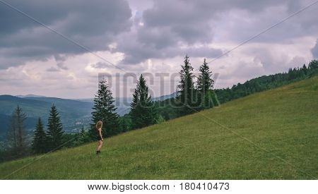 Girl on a mountain in Carpathians looks ahead