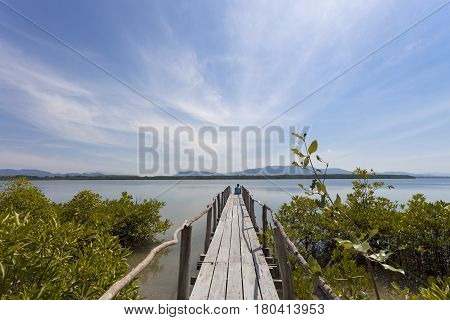 man sitting relaxed on a pier staring at the sea in sunny good weather day