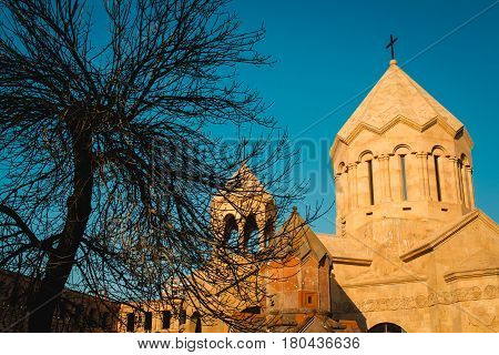 Photo of the Katoghike the oldest surviving church in Yerevan and new religious complex with Saint Anna Church. Architecture concept. City center. Armenia. Leafless tree. Medieval chapel