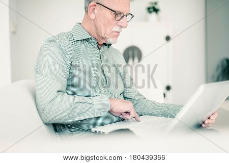 Senior Man Working With Laptop On Couch At Home.