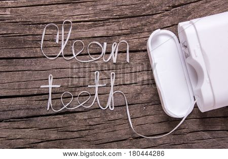 Words clean teeth of dental floss on an old wooden table