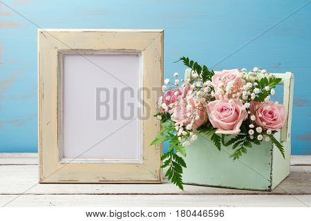 Poster mock up template with rose flower bouquet in box over wooden background