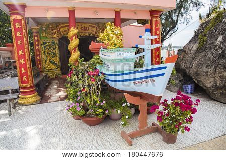 Phu Quoc, Vietnam - Mar 19, 2017: Wooden boat displayed as a religious symbol at Dinh Cau temple, a famous religious view point on the island.