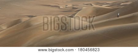 young man walking in sand dunes in Liwa desert in Abu Dhabi