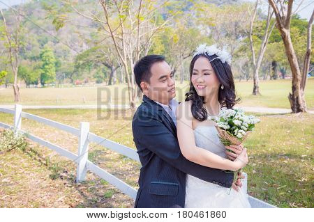 Asian bride and groom happy in park