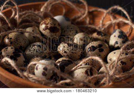 Quail Eggs In Wooden Bowl Isolated On Blue Background Close Up