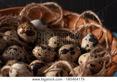 Quail Eggs In Wooden Bowl Isolated On Blue Background Close Up