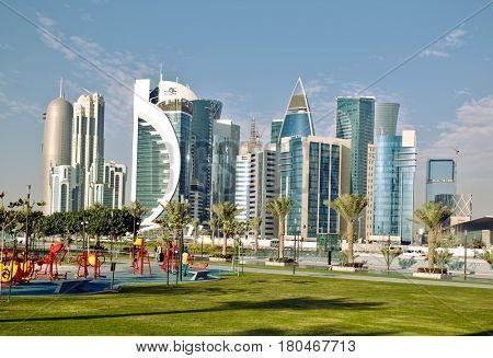 DOHA, QATAR - FEBRUARY 17, 2016: The high-rise district of Doha, seen from the recently completed Hotel Park, with a children's playground in the foreground.