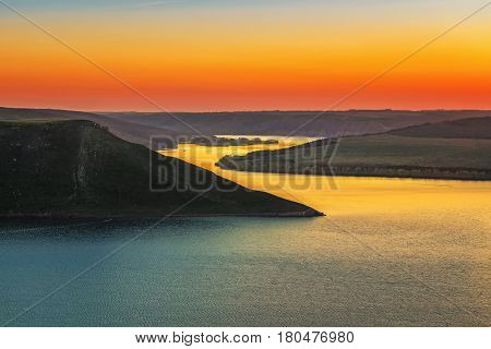 Magnificent sunset scenery on the Dniester canyon and curves river with colorful evening sky reflected in the water
