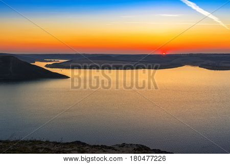 Magnificent sunset scenery on the Dniester river with colorful evening sky reflected in the water