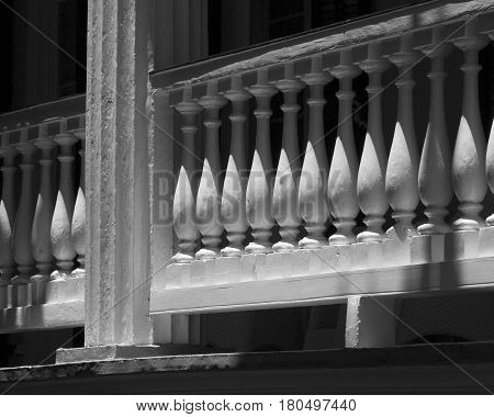 The balusters of a colonial style balcony in Charleston, South Carolina form an abstract repetition of shapes and shadows