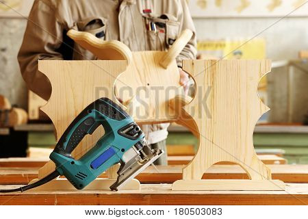 Woodwork with electric jigsaw in a carpentry