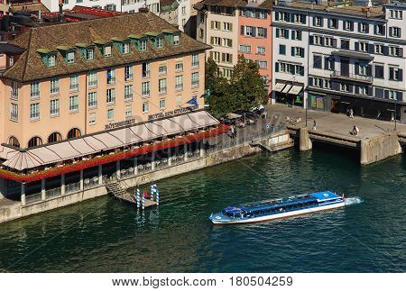 Zurich, Switzerland - 31 August, 2015: the Limmat river and buildings along it, people on the embankment of the river, as seen from the tower of the Grossmunster Cathedral. Zurich is the largest city in Switzerland.