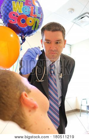 Image of doctor checking patients eyes with a penlight
